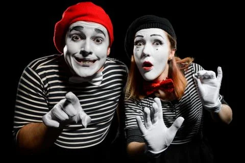 Curious mimes looking at camera. Funny performance by pantomime clowns Stock Photos