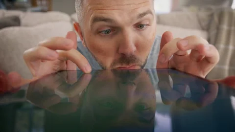 Curious nerd search, Funny male looks closely on tablet devise screen online 4K Stock Footage 256111401
