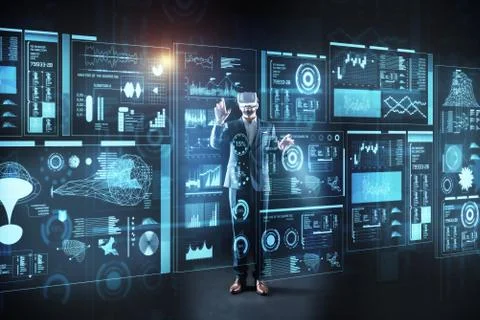 Curious programmer standing in front of a screen in virtual reality glasses Stock-Fotos