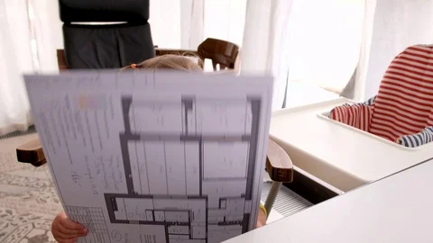 Curious small kid examining draft pretending adult in parent workplace at home Stock Footage 127098569