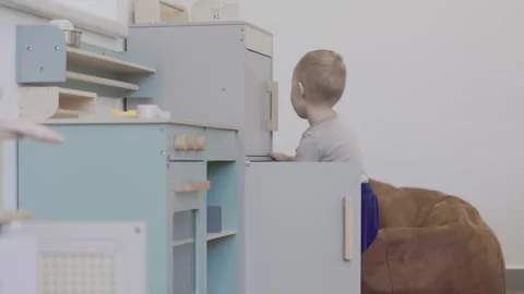 Curious toddler boy opening kitchen cabinet 库存影片 294340915