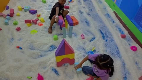 Curious toddler exploring and touching fake snow with joyful expression 스톡 사진