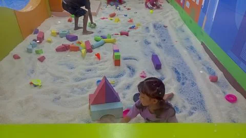 Curious toddler exploring and touching fake snow with joyful expression Stock Photos