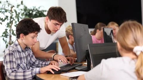 Curious underage boy engaged in IT training with help of teacher in computer Video stock 275004330