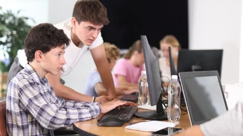 Curious underage boy engaged in IT training with help of teacher in computer Stock Footage 342126892