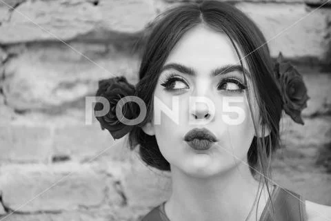 Curious woman with red lips and fresh roses in hair Stock Photos