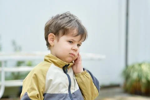Curious young boy exploring the backyard on a sunny day Stock Photos