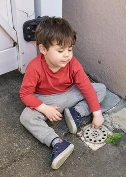 Curious young boy exploring the backyard on a sunny day Stock Photos