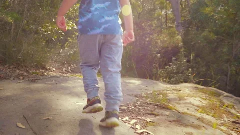 Curious young boy exploring on a bush track and looking back, slow motion Stock Footage 130229832