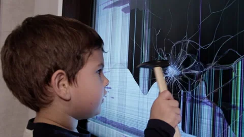 A Curious Young Boy Fixes a Broken Screen with a Determined Expression Stock Footage 257573859