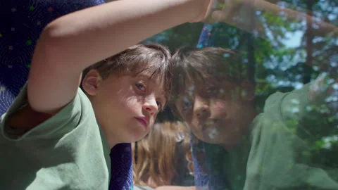 Curious young boy rides a bus, leaning on window and gazing outside, thoughtful Video stock 313068648
