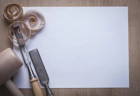 Curled wood shavings solid chisel lump hammer and blank sheet of paper on wooden Stock Photos