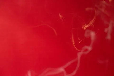 Curls of smoke on a red background Stock Photos