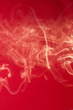 Curls of smoke on a red background Stock Photos