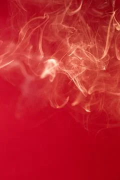 Curls of smoke on a red background Stock Photos