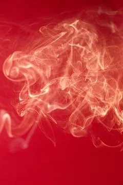 Curls of smoke on a red background Stock Photos