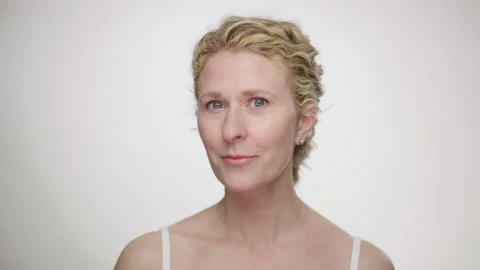 Curly blonde model looks into camera as she admires her appearance in reflection 스톡 동영상 193824527