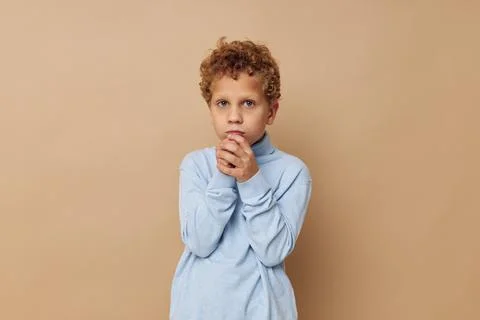 Curly boy in a blue sweater posing fun childhood unaltered Stock Photos