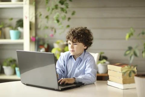 Curly boy sits at the note of beech at home Stock Photos