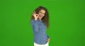 The curly businesswoman gesture ok and stand on the green background. Real time 4k or 4k+ Resolution