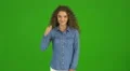 The curly businesswoman thumb up and stand on the green background. Real time 4k or 4k+ Resolution