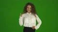 The curly businesswoman thumb up and stand on the green background. Real time 4k or 4k+ Resolution
