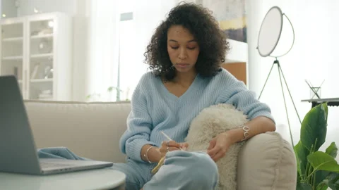 Curly female thinking through creative plot writing, life or debt release plan Video stock 262380557