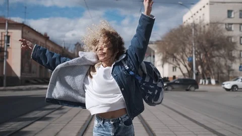 Curly girl fun dancing walking around the city. carefree teenager is smiling and Stock Footage 123710287