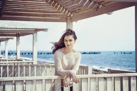 Curly girl smiling in the gazebo on the sea background Stock Photos