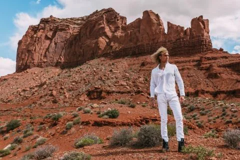 A curly haired blonde man posing around the famous Buttes of Monument Valley  Stock Photos