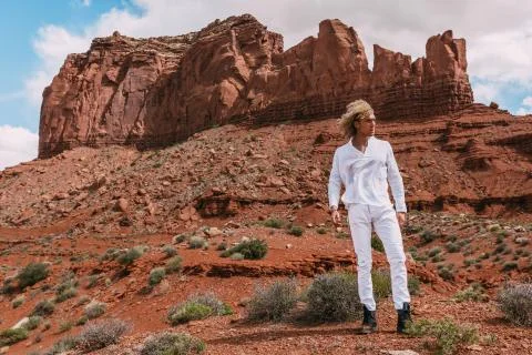 A curly haired blonde man posing around the famous Buttes of Monument Valley  Stock Photos