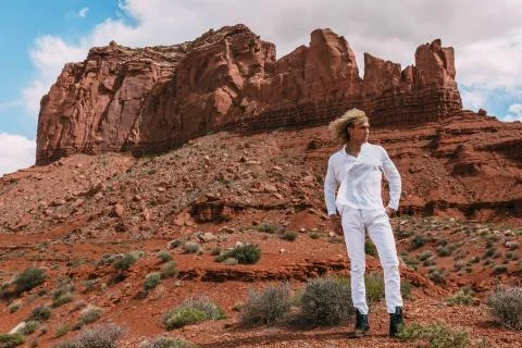 A curly haired blonde man posing around the famous Buttes of Monument Valley  Stock Photos
