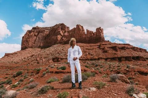 A curly haired blonde man posing around the famous Buttes of Monument Valley  Stock Photos