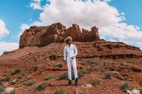 A curly haired blonde man posing around the famous Buttes of Monument Valley  Stock Photos