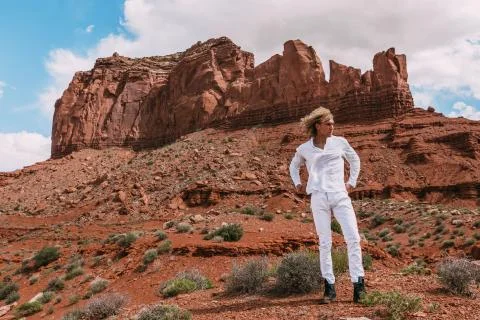 A curly haired blonde man posing around the famous Buttes of Monument Valley  Stock Photos