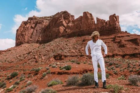 A curly haired blonde man posing around the famous Buttes of Monument Valley  Stock Photos
