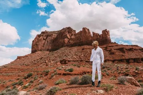 A curly haired blonde man posing around the famous Buttes of Monument Valley  Stock Photos