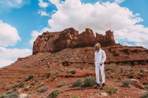 A curly haired blonde man posing around the famous Buttes of Monument Valley  Stock Photos
