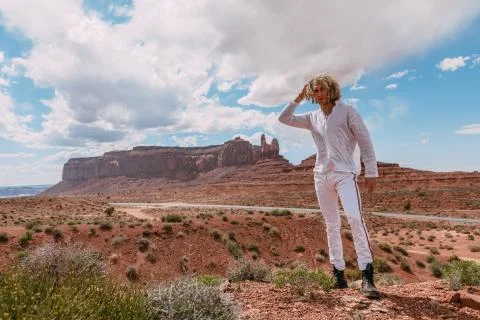 A curly haired blonde man posing around the famous Buttes of Monument Valley  Stock Photos
