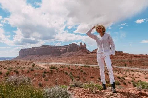 A curly haired blonde man posing around the famous Buttes of Monument Valley  Stock Photos