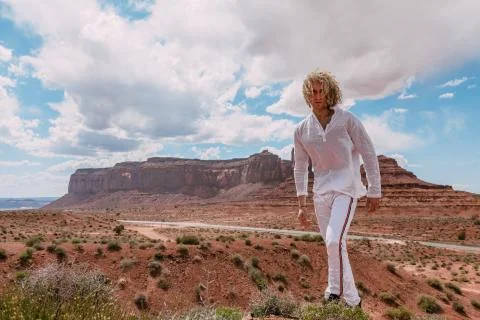 A curly haired blonde man posing around the famous Buttes of Monument Valley  Stock Photos