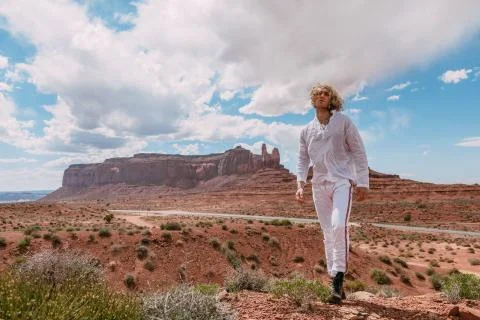 A curly haired blonde man posing around the famous Buttes of Monument Valley  Stock Photos