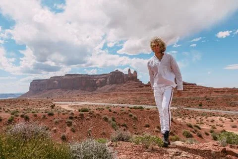 A curly haired blonde man posing around the famous Buttes of Monument Valley  Stock Photos
