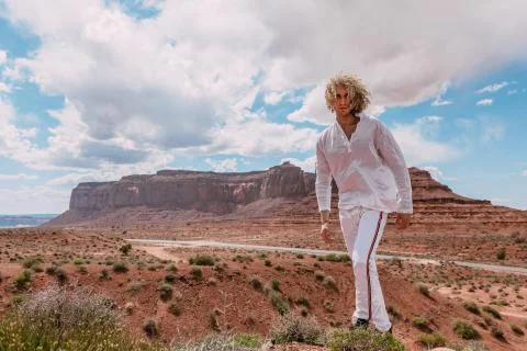 A curly haired blonde man posing around the famous Buttes of Monument Valley  Stock Photos