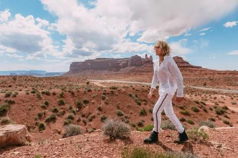 A curly haired blonde man posing around the famous Buttes of Monument Valley  Stock Photos