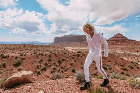 A curly haired blonde man posing around the famous Buttes of Monument Valley  Stock Photos