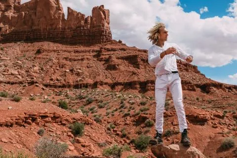 A curly haired blonde man posing around the famous Buttes of Monument Valley  Stock Photos