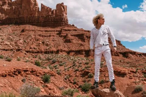 A curly haired blonde man posing around the famous Buttes of Monument Valley  Stock Photos