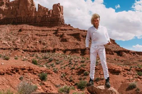 A curly haired blonde man posing around the famous Buttes of Monument Valley  Stock Photos