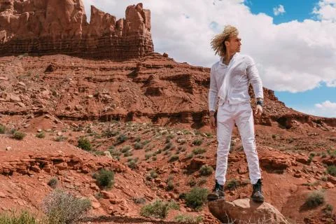 A curly haired blonde man posing around the famous Buttes of Monument Valley  Stock Photos